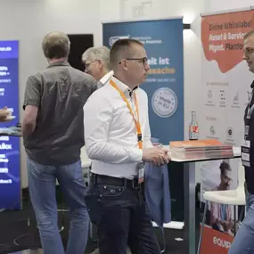 Besucher im Gespräch am Messestand, IT-Software und Whitelabel-Plattformen